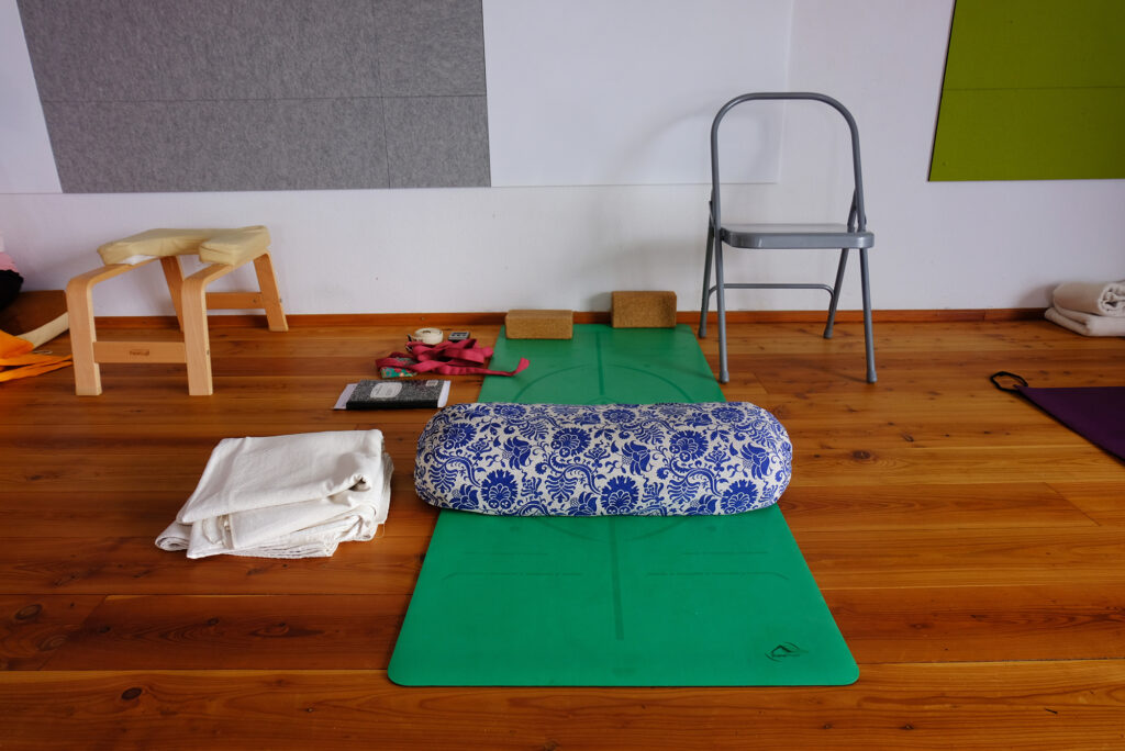 Matte, Kissen, Gurt, 2 Blöcke, Kopfstandhilfe, 2 Decken in einem Seminarraum