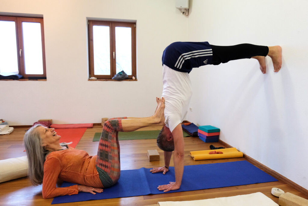 Monika hilft Schüler beim Üben des halben Handstands, Seminarhaus Holzmannstett
