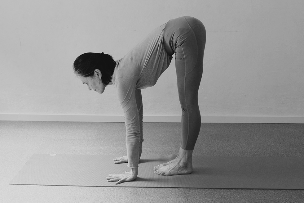 Yogalehrerin Petra in einer Vorbeuge, Füße und Hände fest auf dem Boden