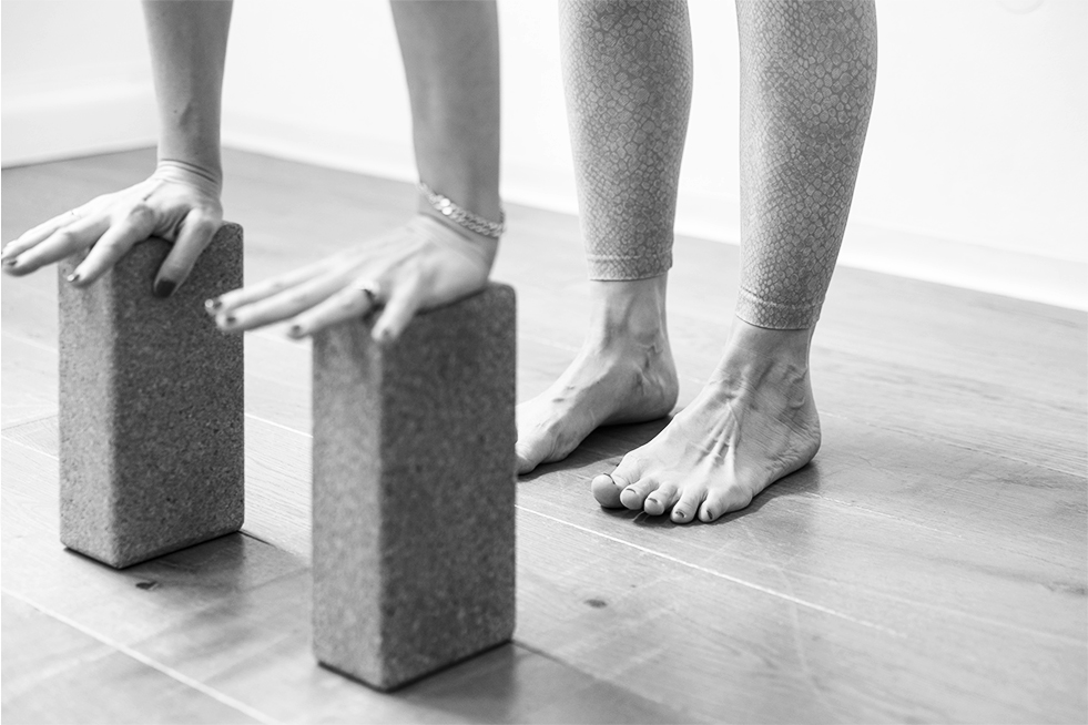 Yoga-Lehrerin übt Vorbeuge mit Klötzen