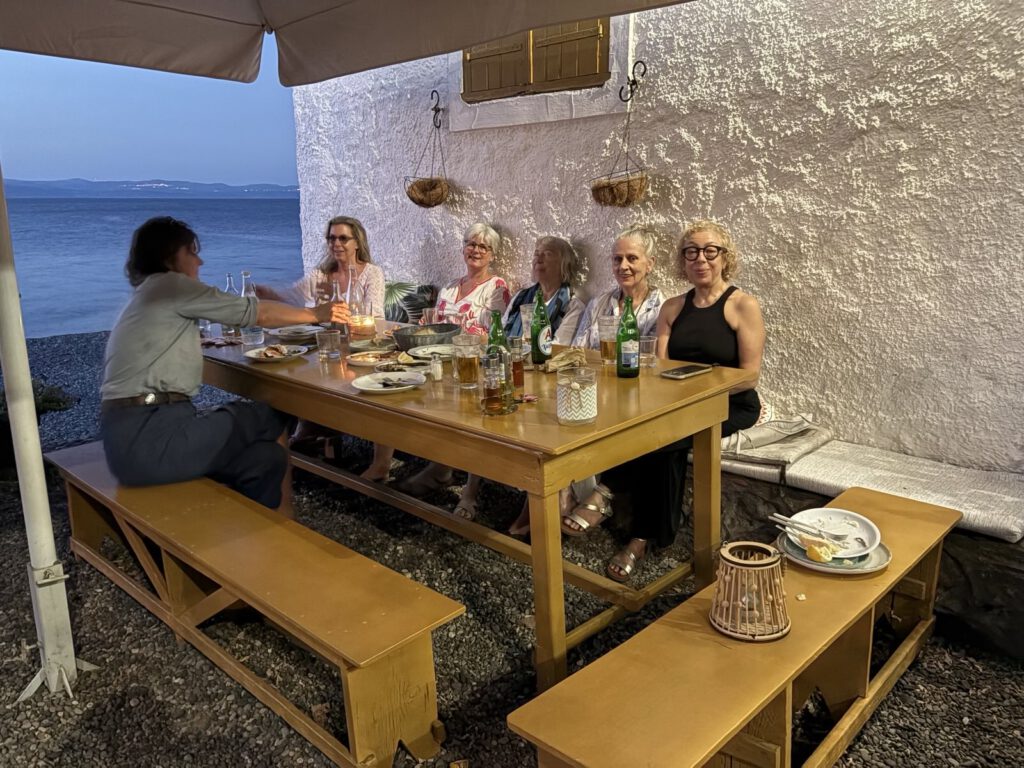 5 gutgelaunte Yoga-Retreat-Teilnehmerinnen am Tich in einer griechischen Taverne