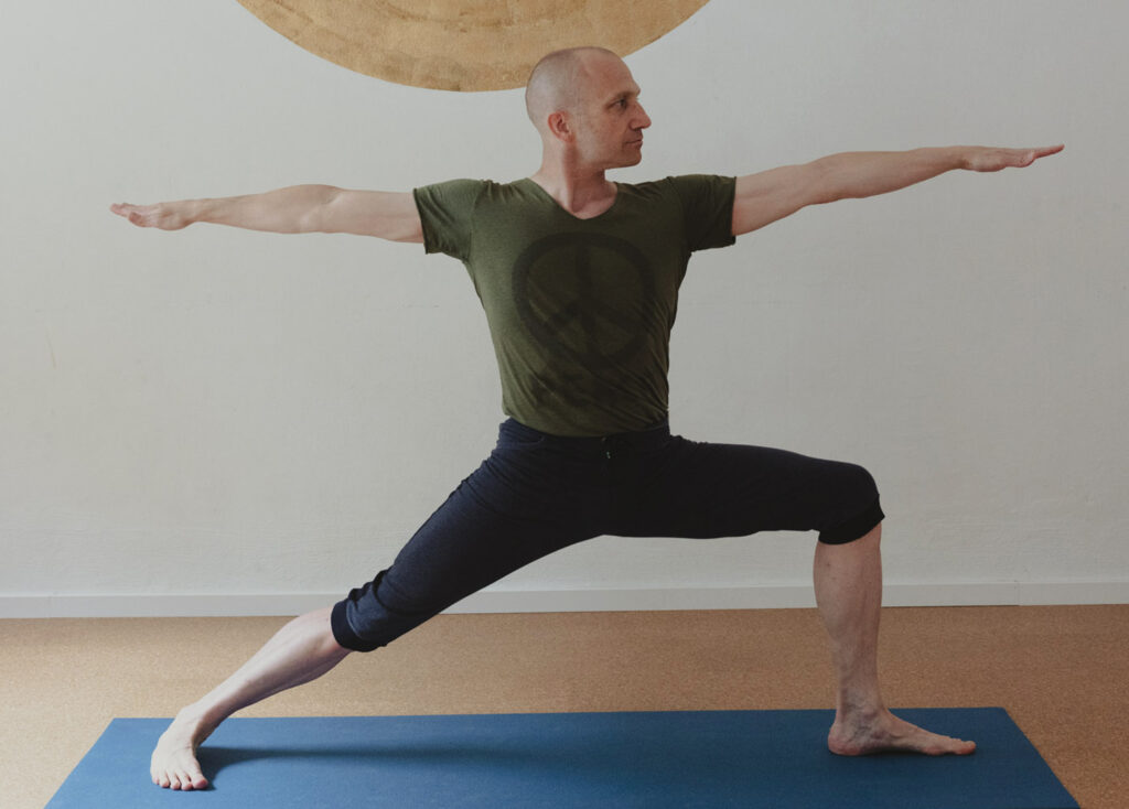 lehrer tobias übt den krieger 2 im yogashala-studio, blick nach rechts