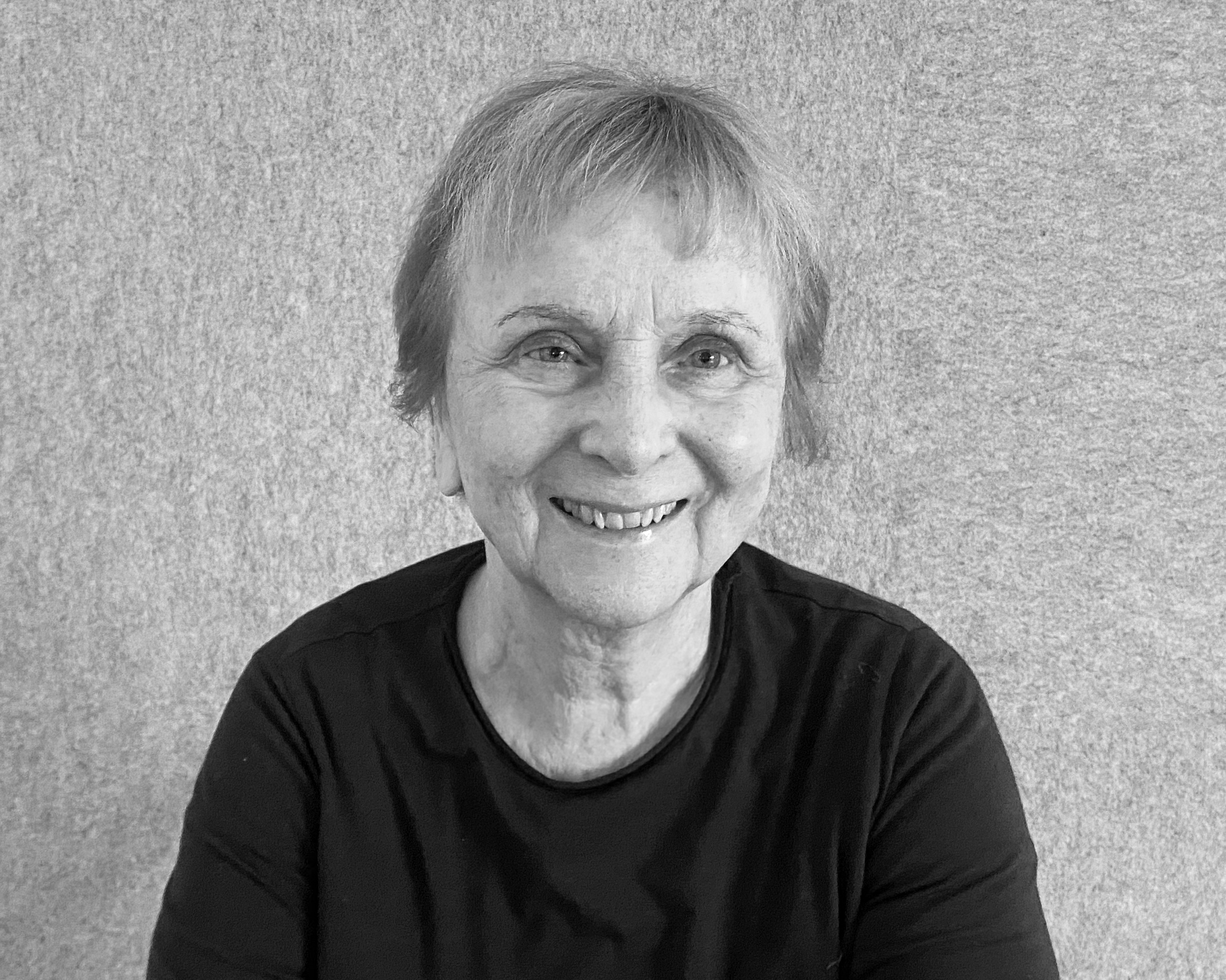 porträt einer dame im mittleren alter, helle kurze haare, dunkler pulli, lächelnd