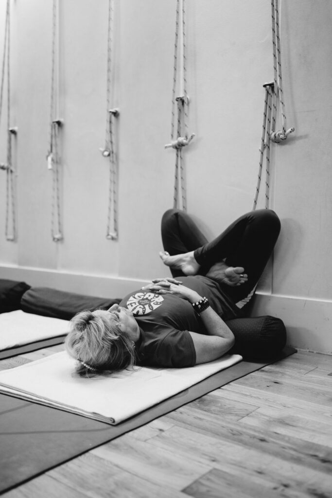 Jayne Orton im Yogashala, liegend vor Wand