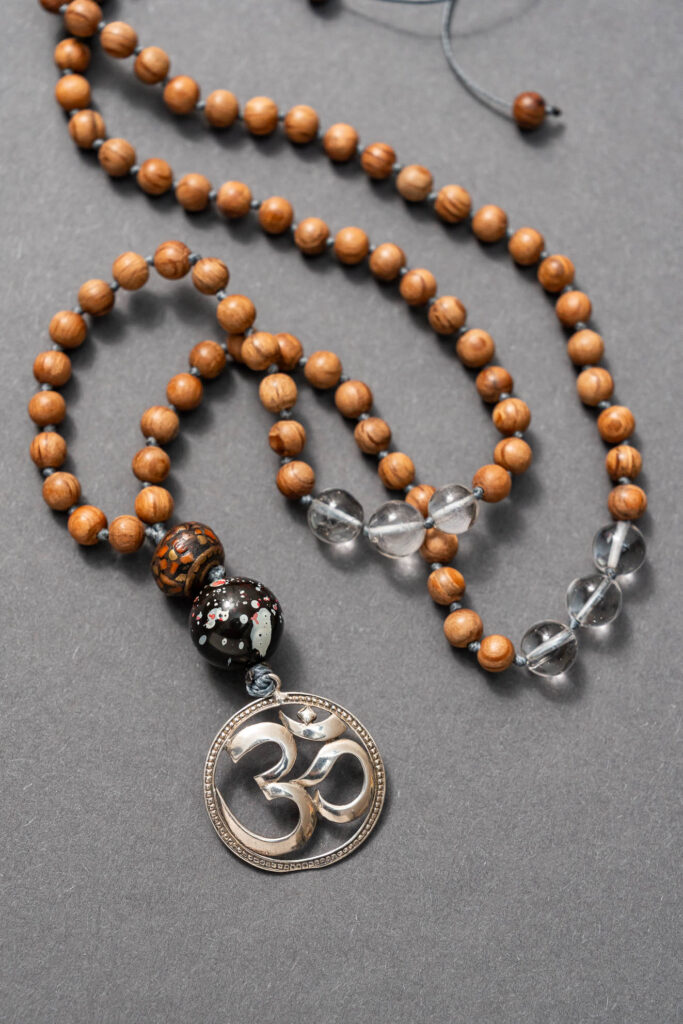 Mala mit Naturholzperlen und Anhänger aus Metall mit "OM"-Schriftzug