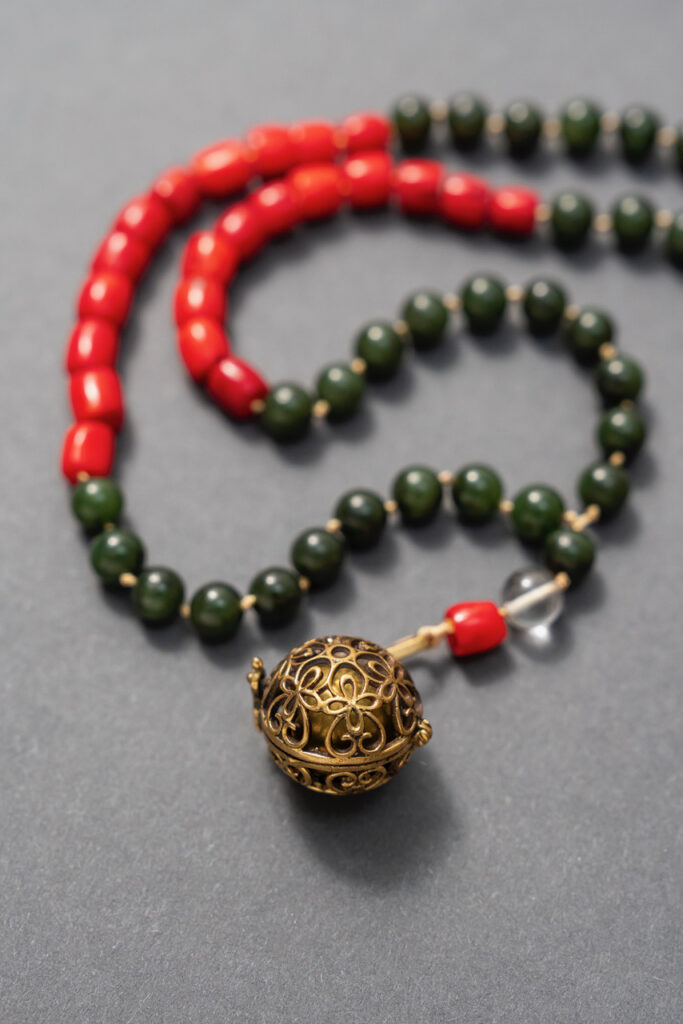 Mala-Kette mit grünen und roten Perlen und Kugel mit Blumenmuster als Anhänger