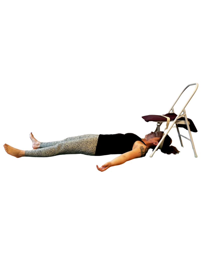 Silke Severin liegt mit dem Kopf unter einem Yoga-Stuhl, der Kopf wird durch einen Gurt leicht oben gehalten