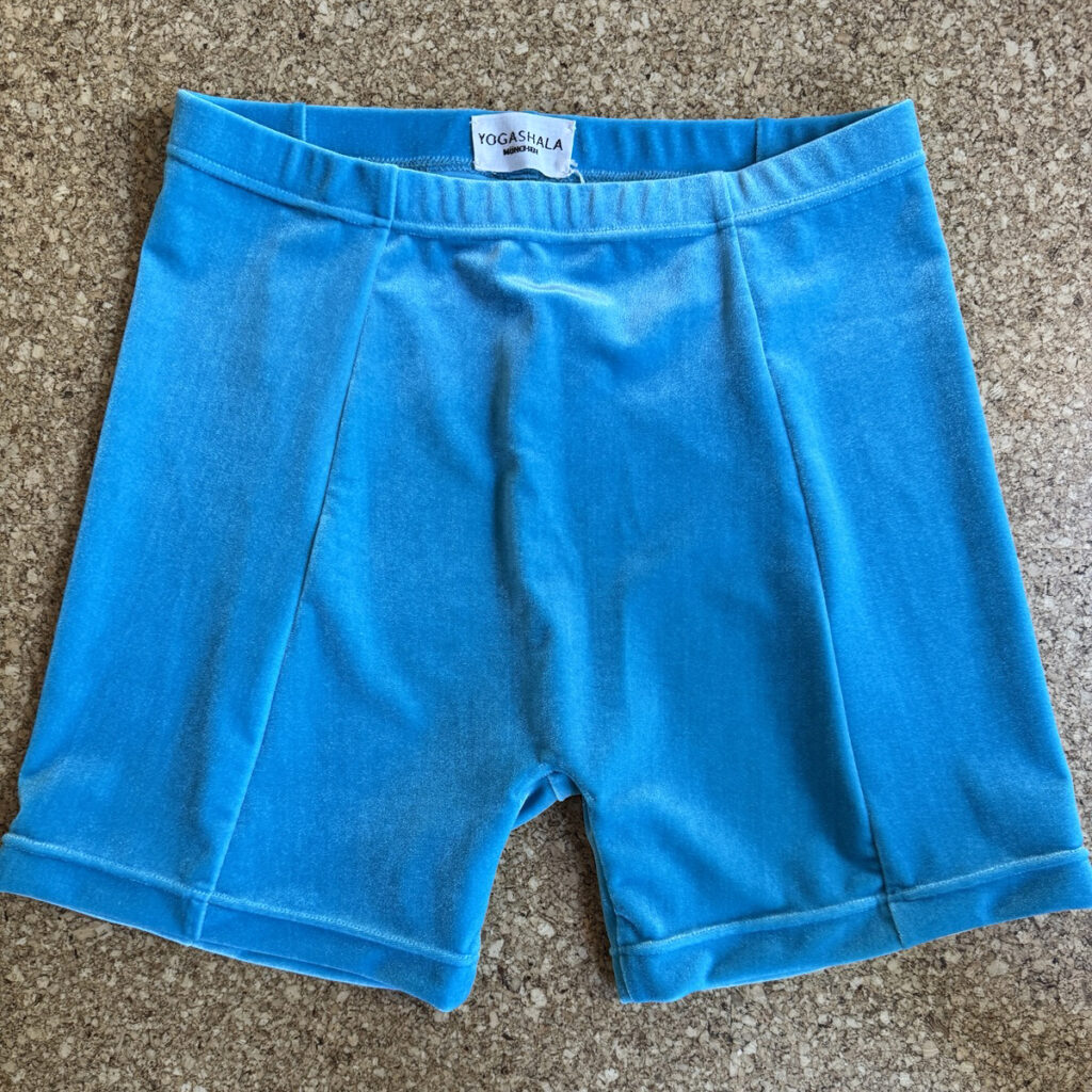 kurze hellblaue Samthose auf Korkboden