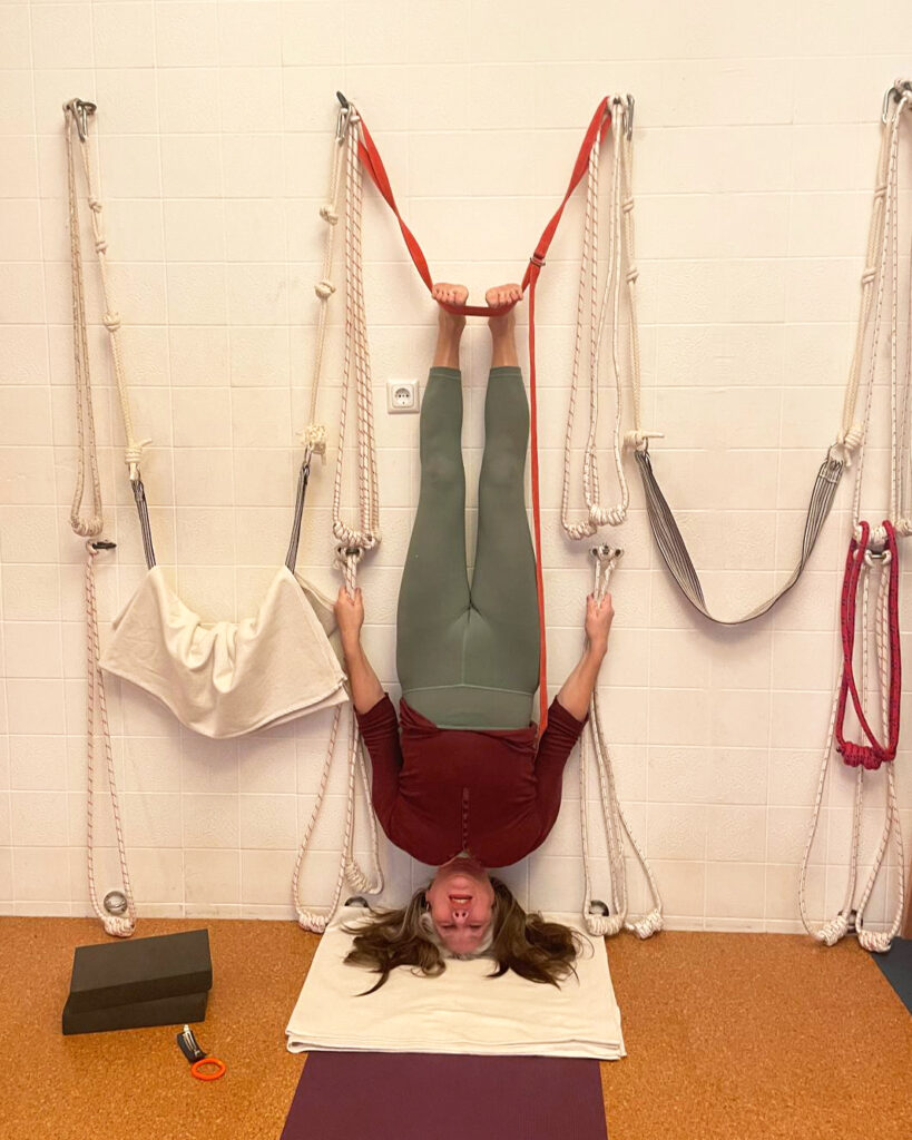Eine Schülerin übt Kopfstand im Seil im Yogashala